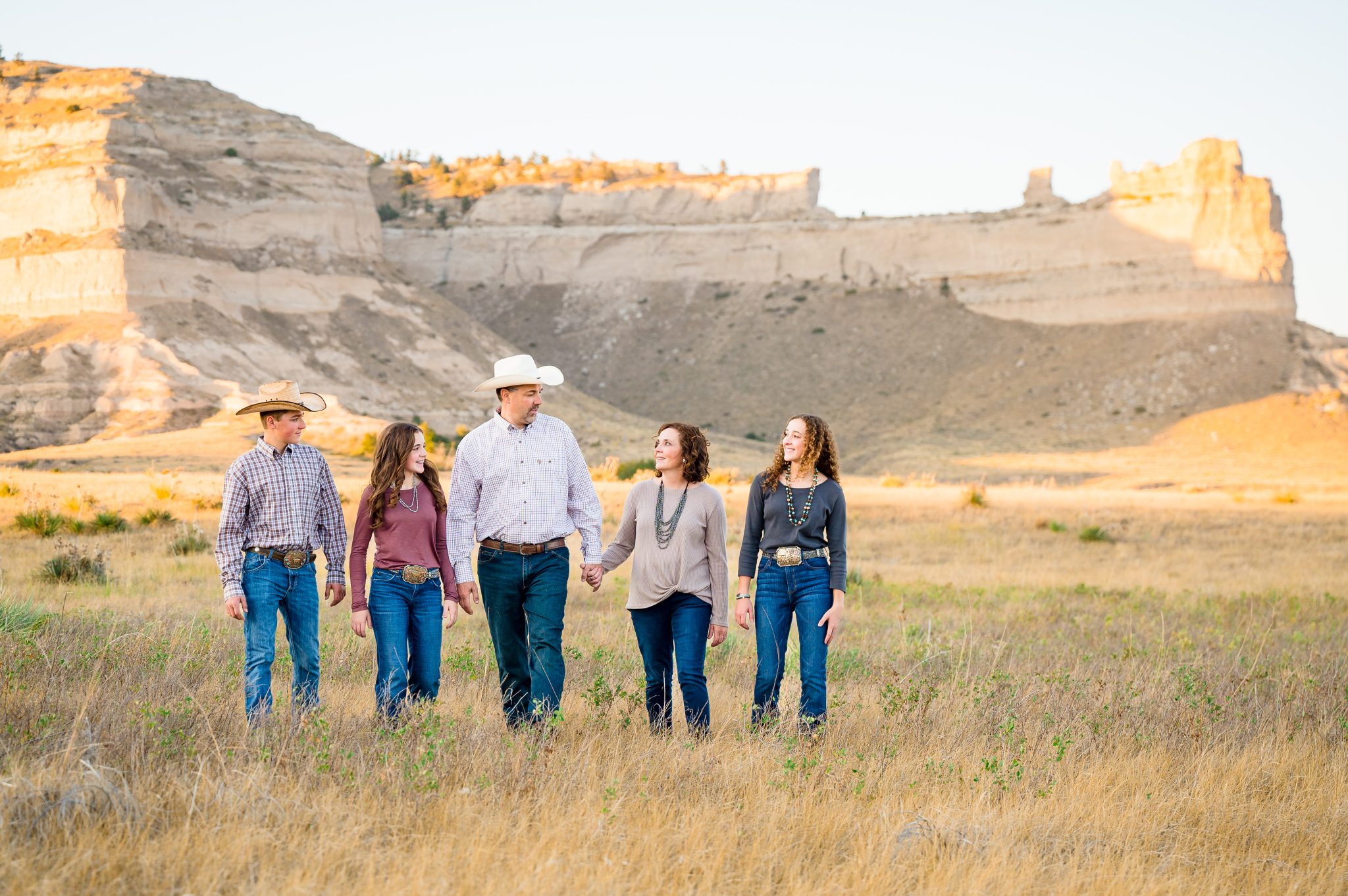 Family walking hand in hand in front of Scotts Bluff National Monument
